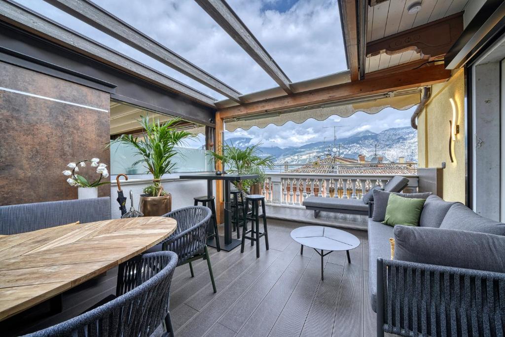 ein Balkon mit Tisch und Stühlen und Aussicht in der Unterkunft City CENTRAL Apartment - Attico Porto Brenzone -lakefront rooftop terrace in Brenzone sul Garda