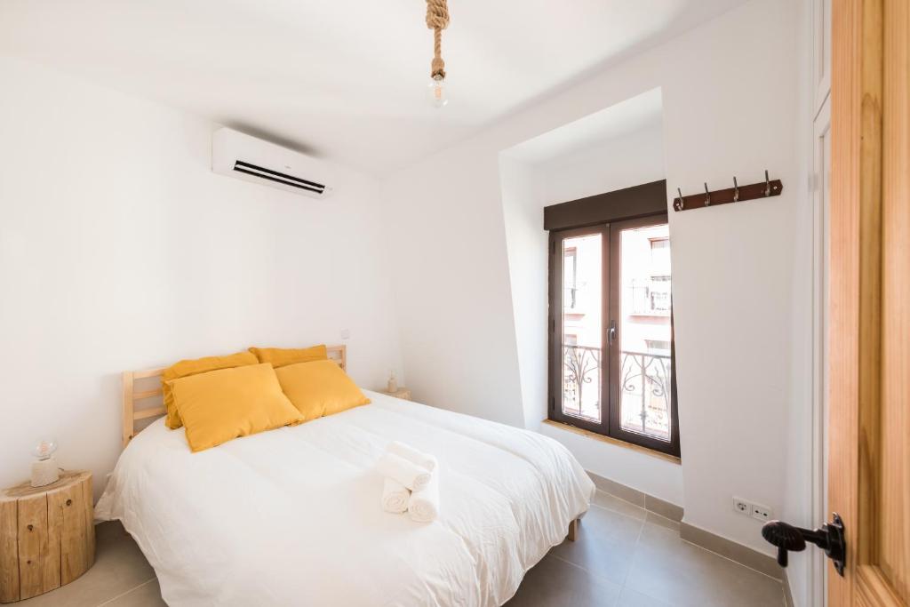 a white bedroom with a bed and a window at Cottage & Vintage in Madrid