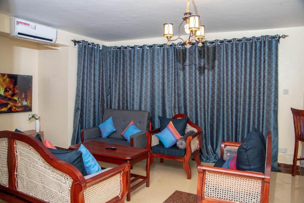 un salon avec des chaises, un canapé et une table dans l'établissement Hera Comfort Homes, à Mombasa