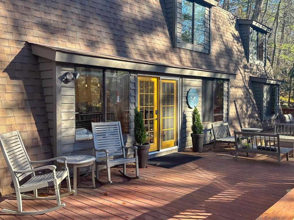 a patio with two chairs and a table on a house at Entire cabin on Lake Sequoyah in Highlands