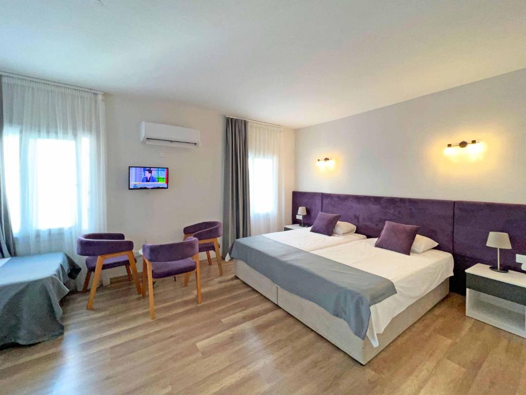 a hotel room with two beds and a table and chairs at Lighthouse Suites by HolidayKeys in Kyrenia