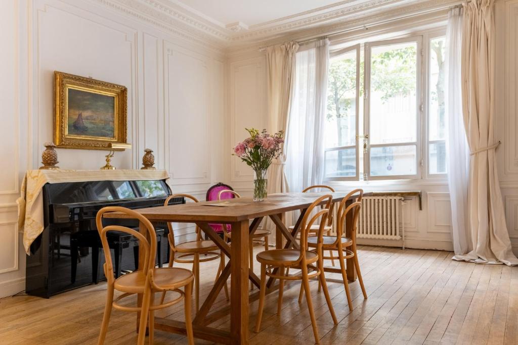 - une salle à manger avec une table, des chaises et un piano dans l'établissement Luxurious 4 Bedroom Apartment next to The Eiffel Tower, à Paris