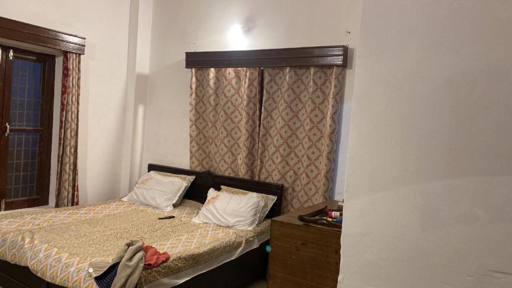 a small bedroom with a bed and a window at Surya hills view in Jāmb