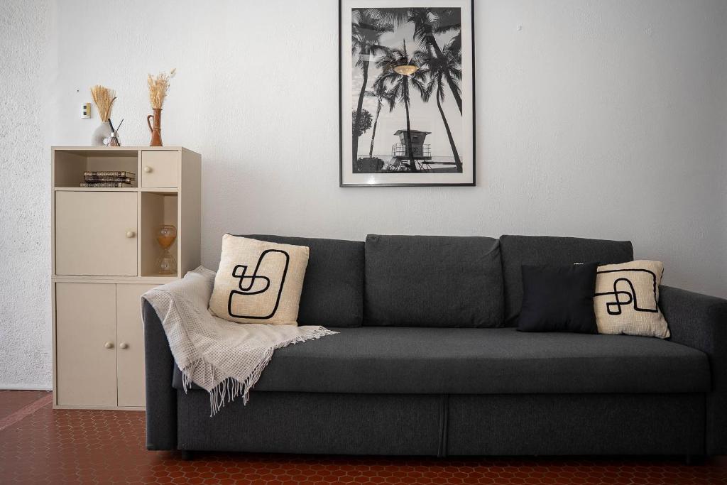 - un salon avec un canapé gris et 2 oreillers dans l'établissement Studio Saint Cyprien plage, à Saint Cyprien Plage