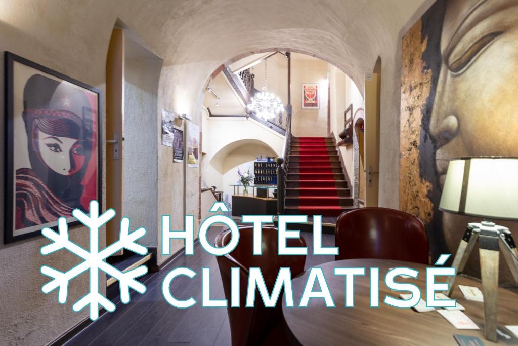 Una habitación con un cartel del comité del hotel en la pared. en Hotel du Clocher, en Rodez