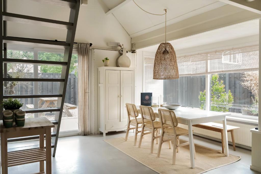 Un comedor con una mesa y sillas blancas. en -Casa Como- nabij het meer, restaurants & keukenhof, en Noordwijkerhout