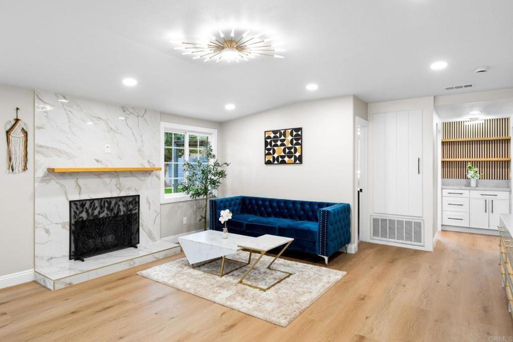 a living room with a blue couch and a fireplace at Xlnc Exotic home13824 Powers Rd in Poway
