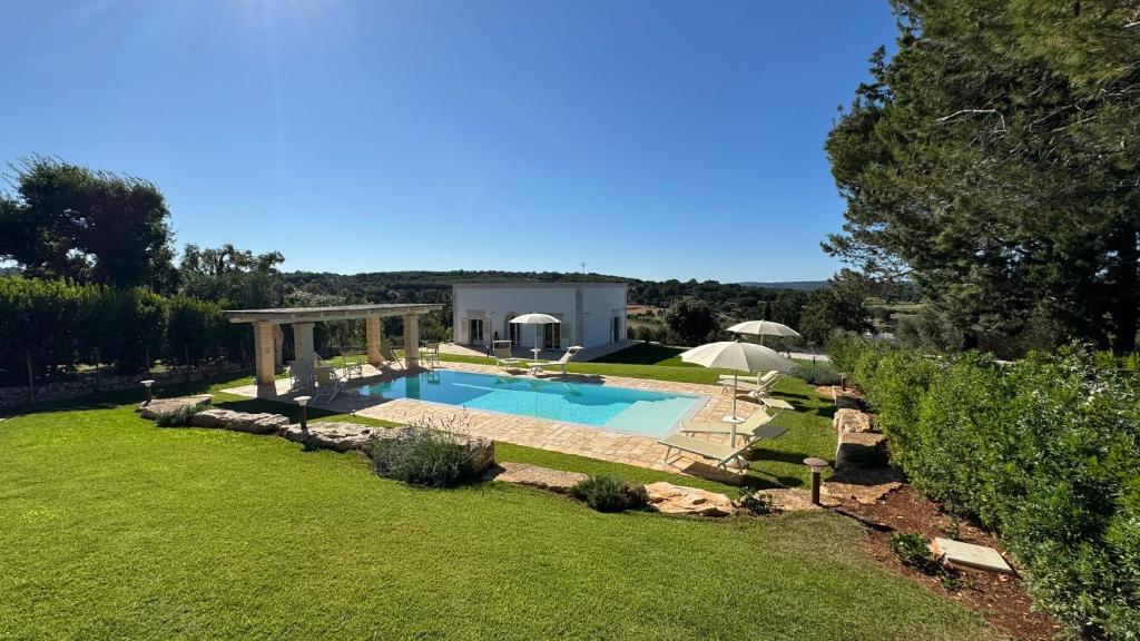 a backyard with a swimming pool and a gazebo at Trullandia in Locorotondo