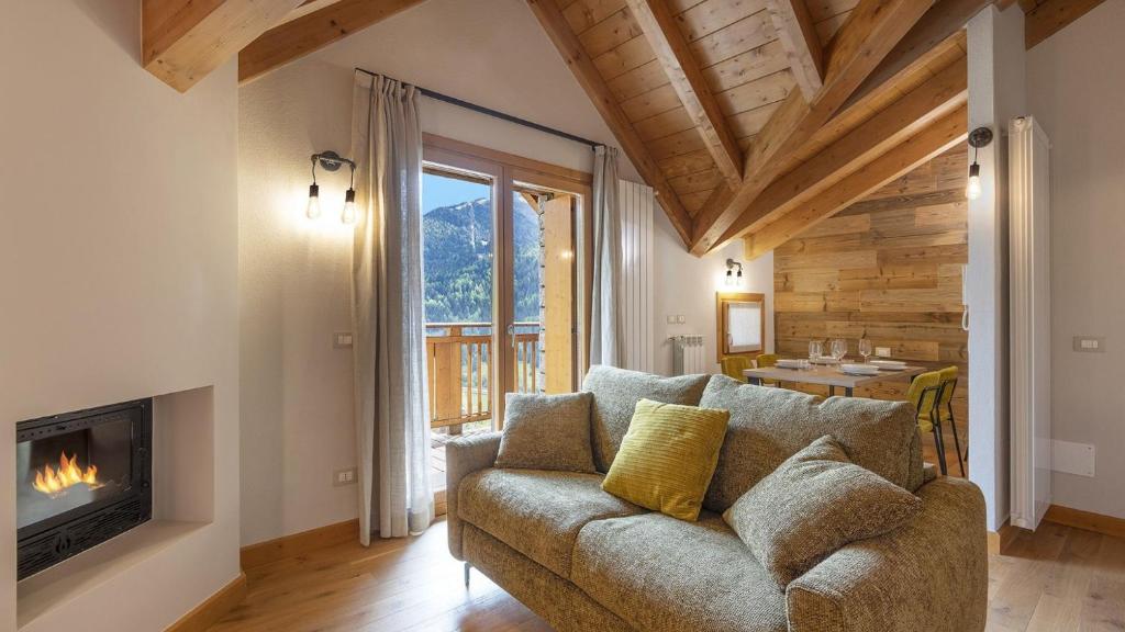 a living room with a couch and a fireplace at Zarabella Delle Alpi in Temù