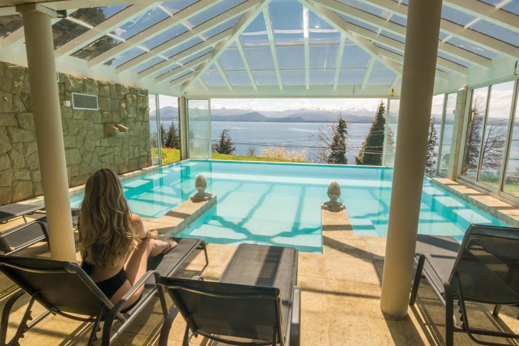 圣卡洛斯-德巴里洛切派拉卡瓦尼亚斯旅馆的坐在游泳池前椅子上的女人