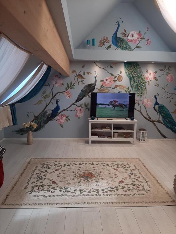 sala de estar con TV y pájaros en la pared en Kuninga Holiday Apartment, en Pärnu