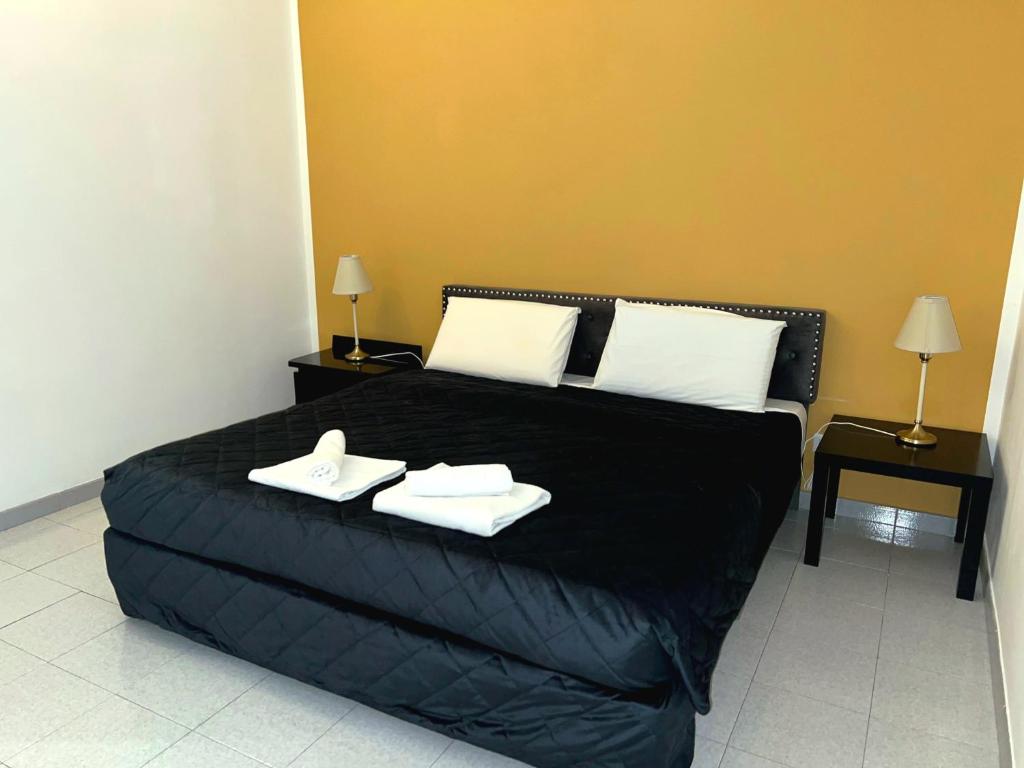 a bedroom with a black bed with two towels on it at Cielo Aperto Bed and Breakfast in Rome