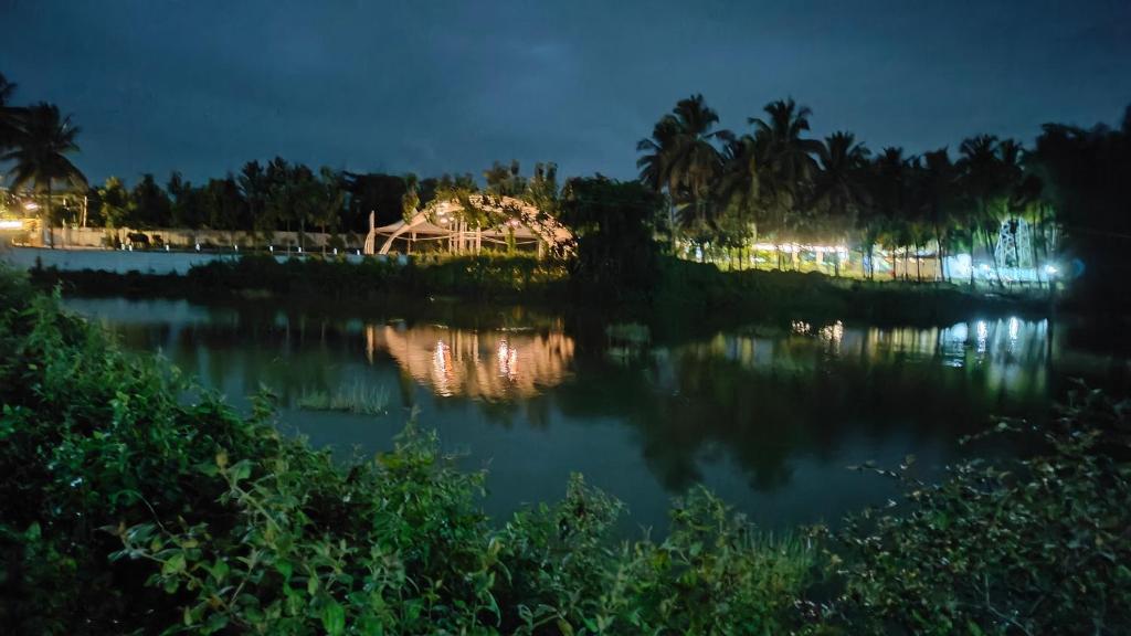 a view of a lake at night at Encanto Farmstay in Mysore