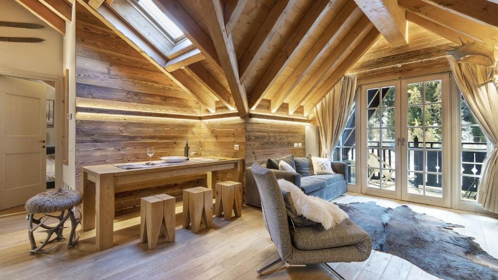 a living room with wooden walls and a wooden ceiling at Alpen Chalet in Ponte di Legno