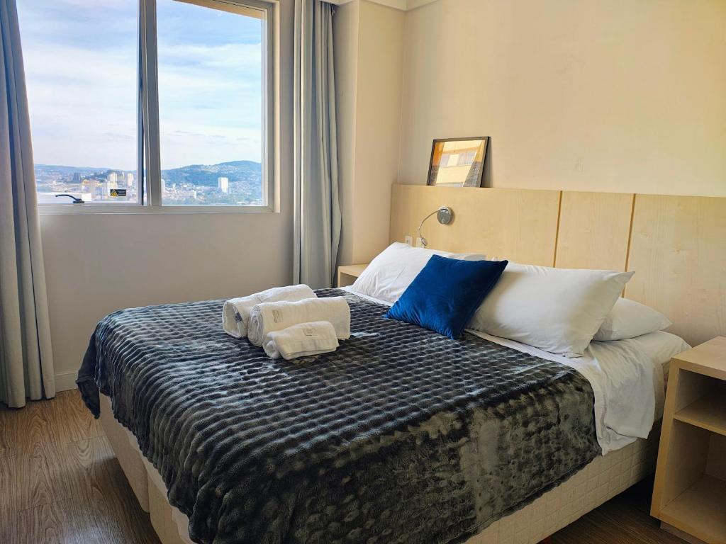 バルエリにあるFlat em Alphaville com a melhor localizaçãoのベッドとタオル2枚のある寝室