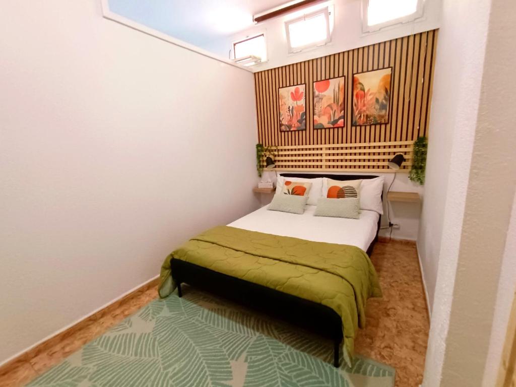 a bedroom with a bed with a green blanket at Bellavista Basement in Costa Del Silencio