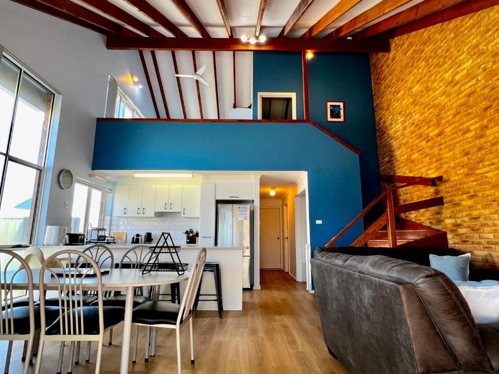 ein Esszimmer und eine Küche mit einer blauen Wand in der Unterkunft Tropical Palms - Kalbarri, WA in Kalbarri