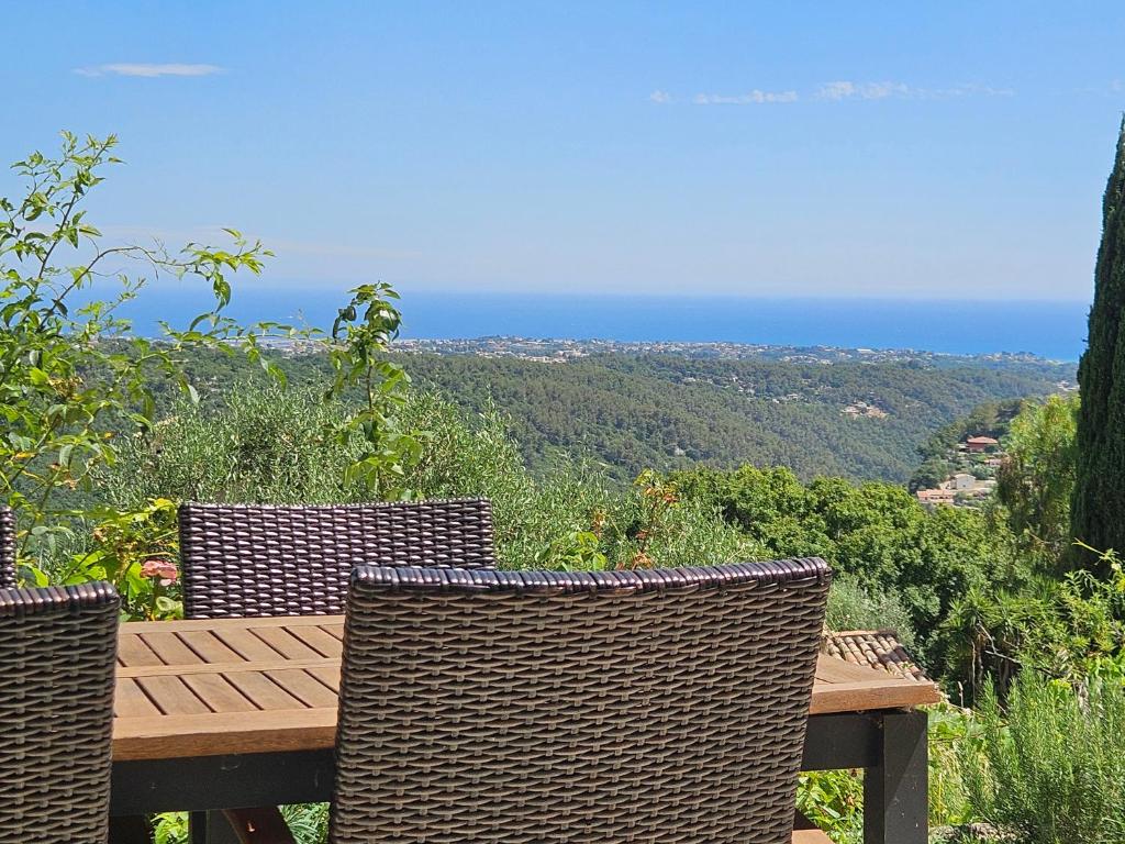 une table et des chaises en bois avec vue sur l'océan dans l'établissement Appartement VUE MER an der Côte d'Azur für 2-3 Personen mit Gartenanteil, à Vence