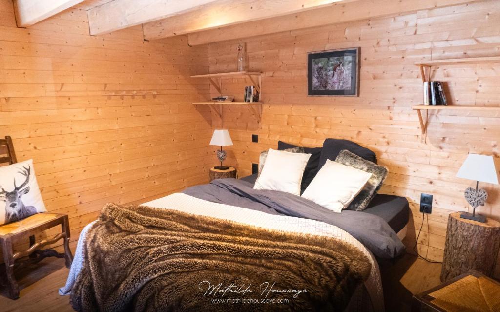 une chambre avec un lit dans un mur en bois dans l'établissement Gite l'Esquirol, à Belvédère