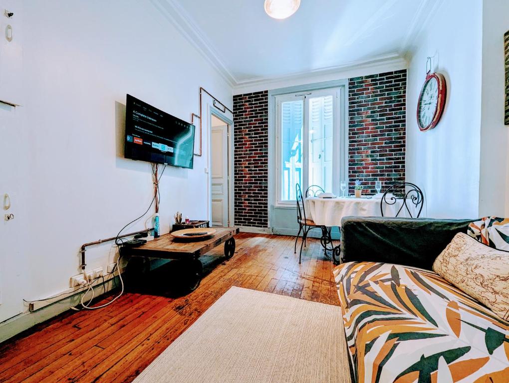 un salon avec un canapé et une table dans l'établissement Chic apart avec parking tout près de Paris, à Saint-Denis
