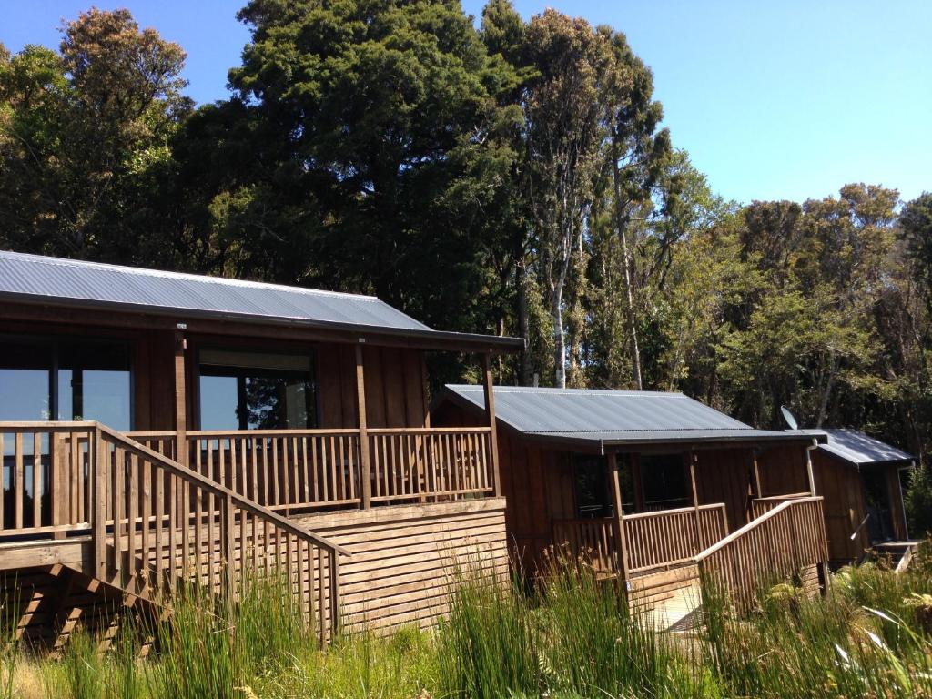 une cabane en rondins avec une terrasse et une maison dans l'établissement Anchorstone, à Half-moon Bay