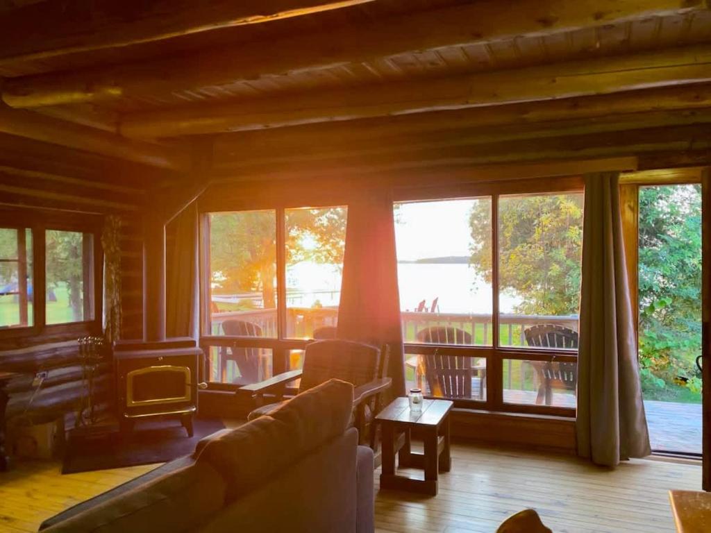 Una sala de estar con un sofá y algunas ventanas. en 3-Bedroom Cottage #7 - Balsam Lake, en Kawartha Lakes