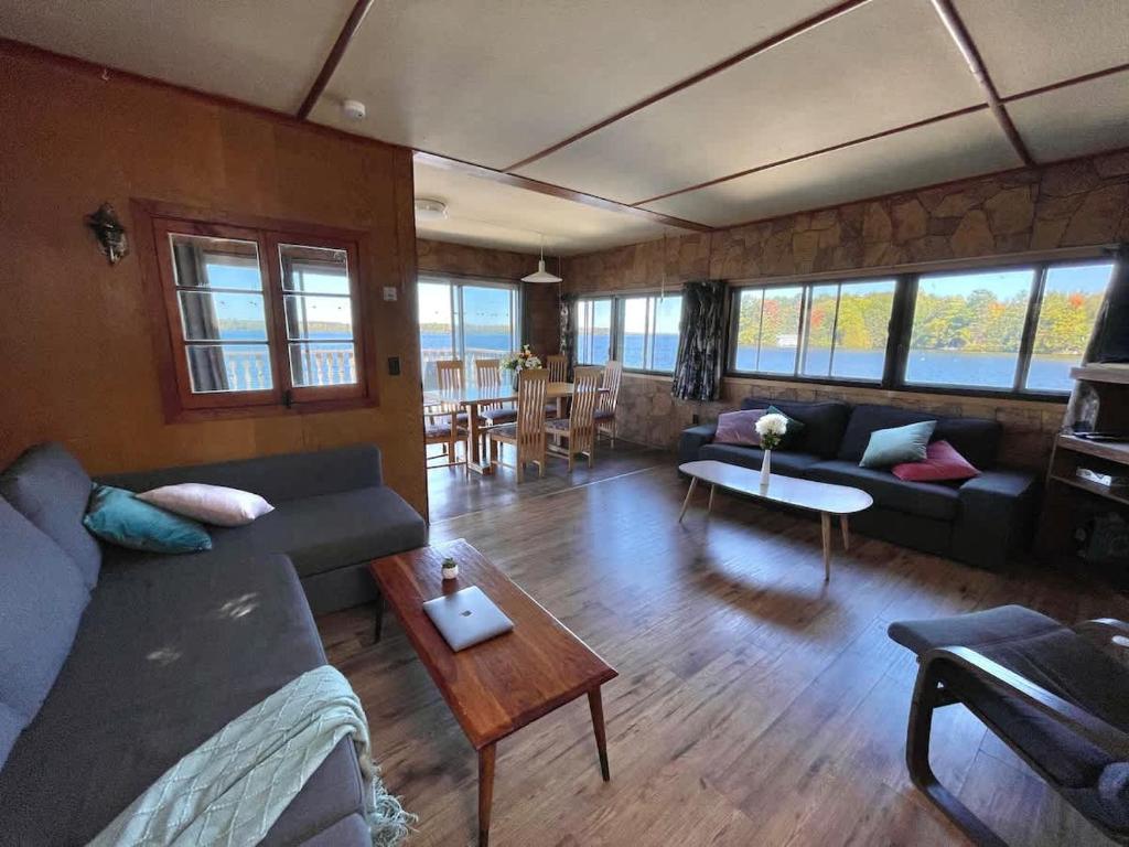 una sala de estar con un sofá y una mesa en Upper Boathouse on Balsam Lake #1, en Kawartha Lakes