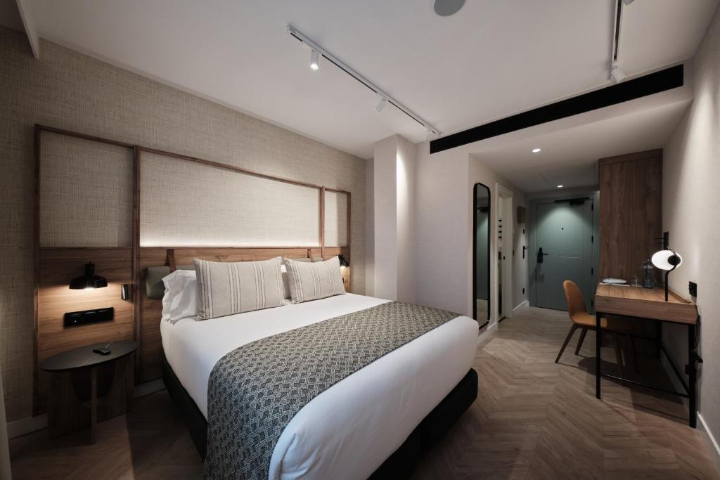 a hotel room with a large bed and a desk at Catalonia Sagrada Familia in Barcelona