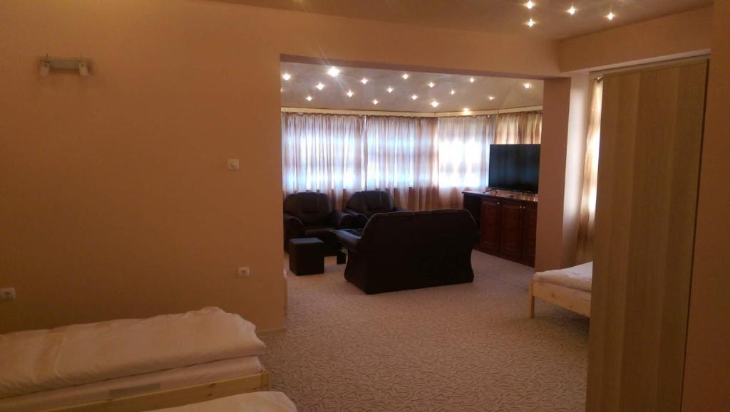 a room with a living room with a couch and a television at Стаи за гости Деметра in Sofia