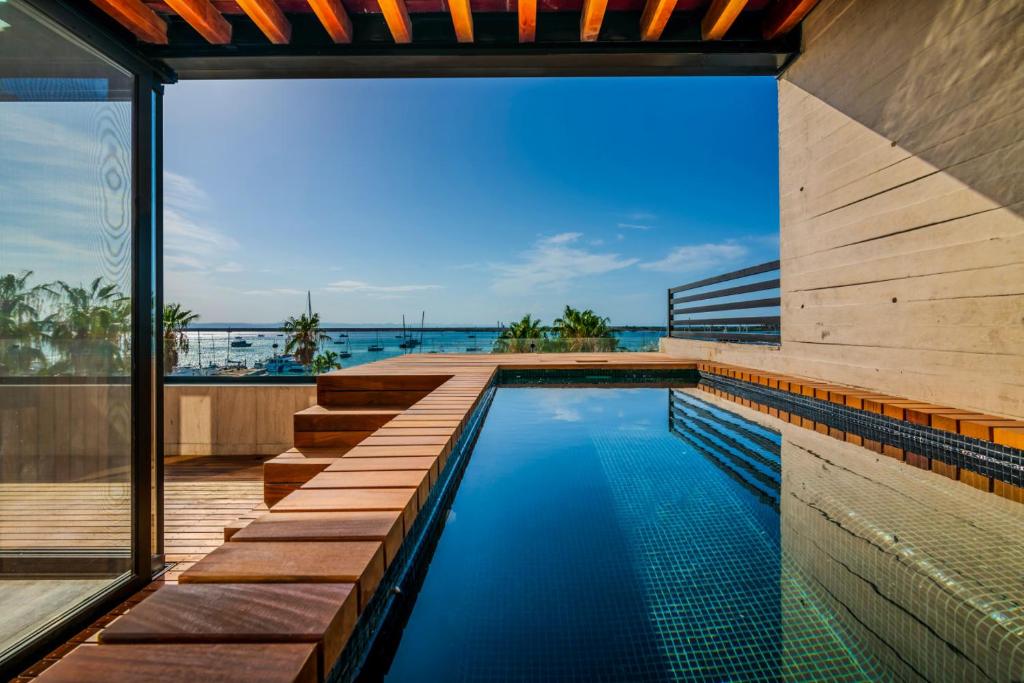an infinity pool with a view of the ocean from a house at Penthouse Vista al Mar, Gimnasio, Terraza, Alberca in La Paz