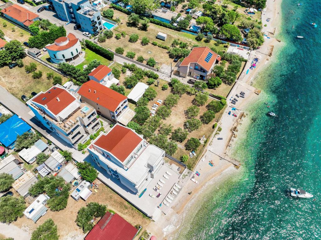 widok z lotu ptaka na plażę z domami i wodą w obiekcie DʻArt Villa w Bibinje