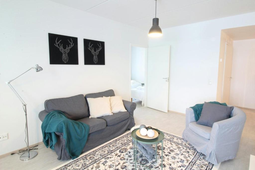 a living room with a couch and two chairs at Spacious Apartment for 4 in Kivistö