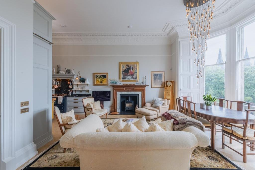 Una sala de estar con un sofá blanco y una mesa. en Luxury West End flat with stunning bay window views, en Edimburgo