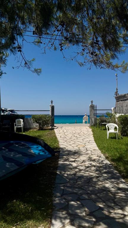 a path leading to a beach with chairs and the ocean at Ionian Sunset in Lefkada