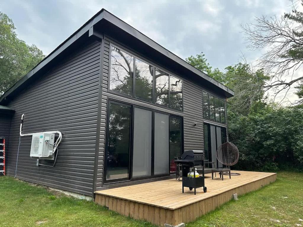 una pequeña casa negra con terraza de madera en 3-bedroom Villa in Lakefield #11, en Lakefield