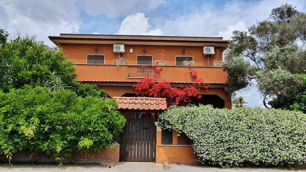 a house with a gate in front of it at Ampie camere in villa in zona verde e tranquilla in Acilia