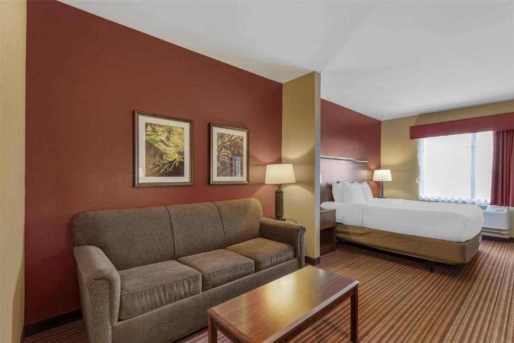 a hotel room with a couch and a bed at Best Western Plus Hudson Hotel & Suites in Hudson