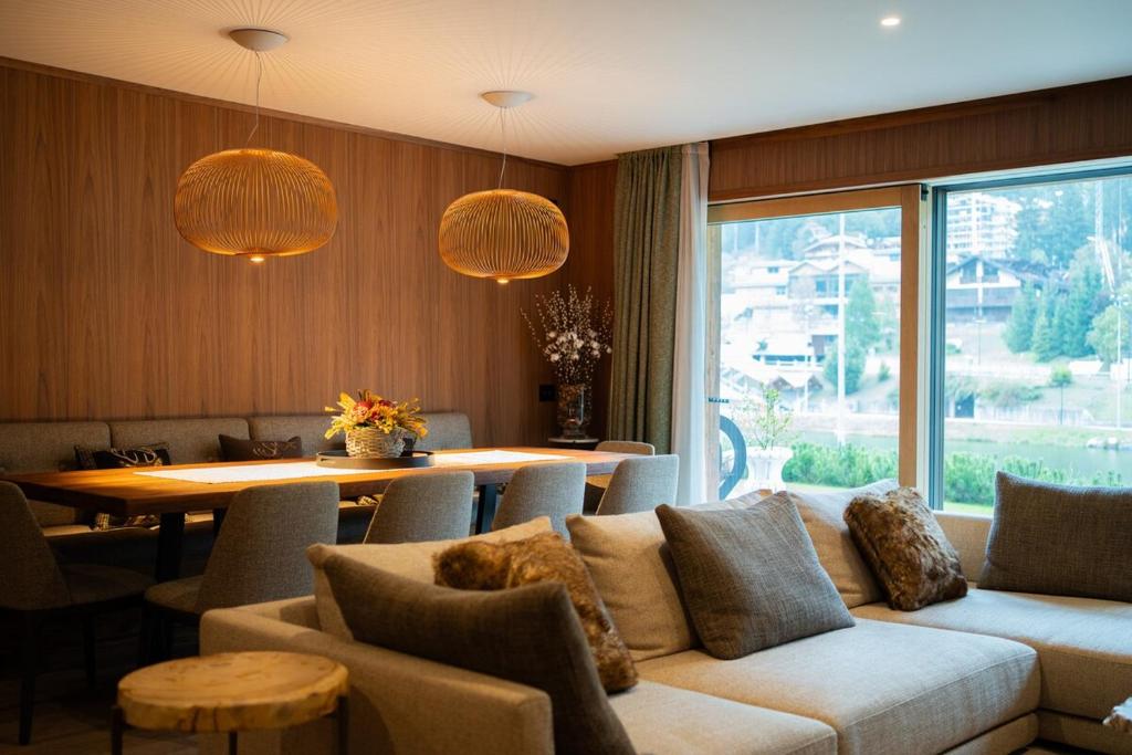 a living room with a couch and a table at Stella Alpina Chalet in Madonna di Campiglio