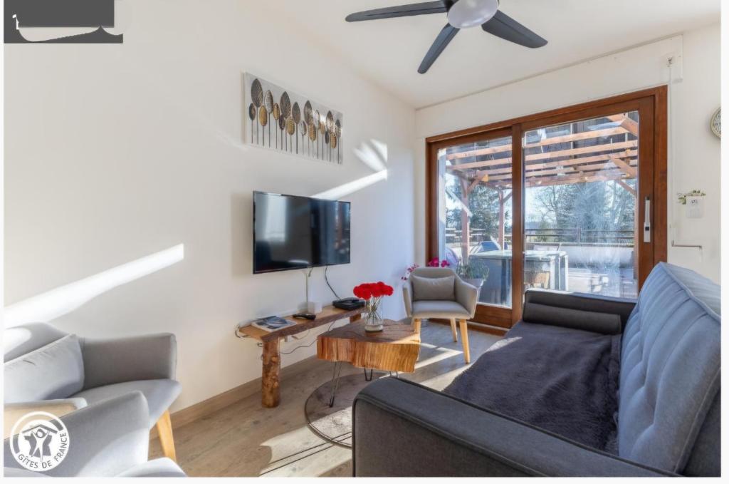 MesseixにあるVacances à la Campagne 4 étoiles à 30min des pistes de ski Mont Dore Sancyのソファと薄型テレビのあるリビングルーム