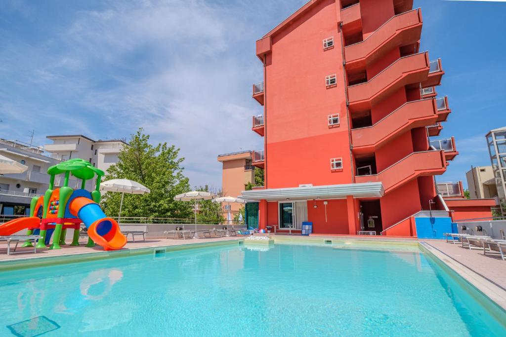einem Pool mit Rutsche vor einem Gebäude in der Unterkunft Family Hotel Mediterraneo - Azzurro Club in Cesenatico