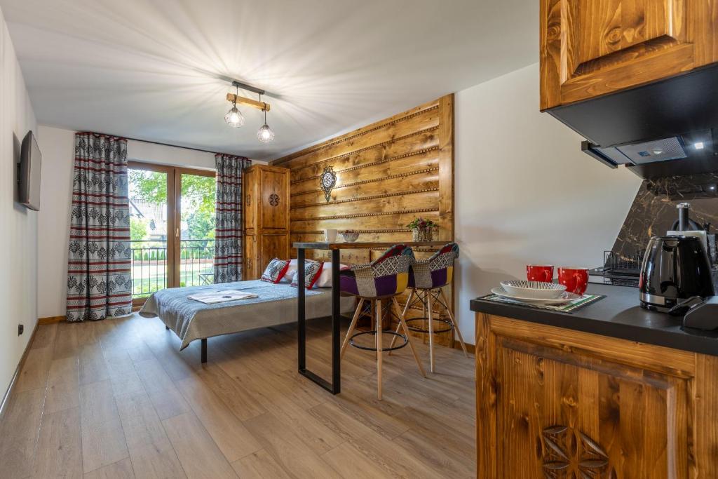 Una cocina con una mesa y una cama en una habitación. en Apartamenty 61, en Poronin