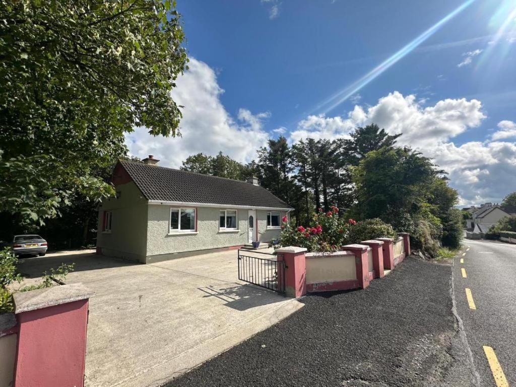 una casa con fiori sul ciglio di una strada di Wild Atlantic Cottage Carrigart a Carrigart
