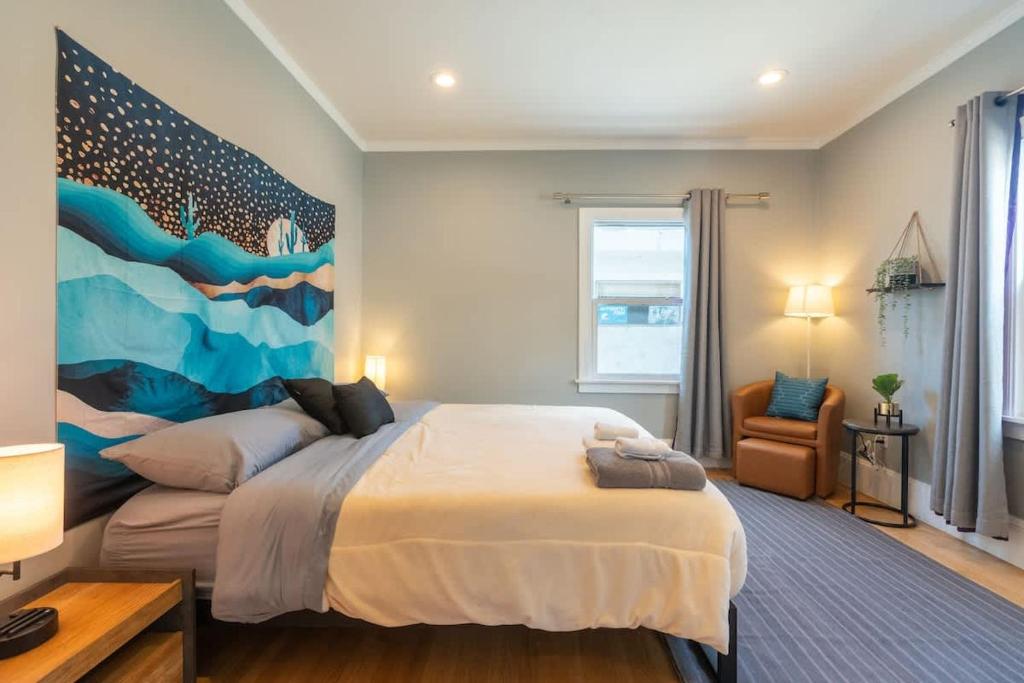オークランドにあるOak Manor - Chic & Stylish 2BR Apartment Retreatの壁に絵が飾られた大きなベッドのある寝室