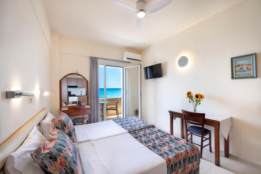 a hotel room with a bed and a desk and a window at Morpheas Apartments in Plakias