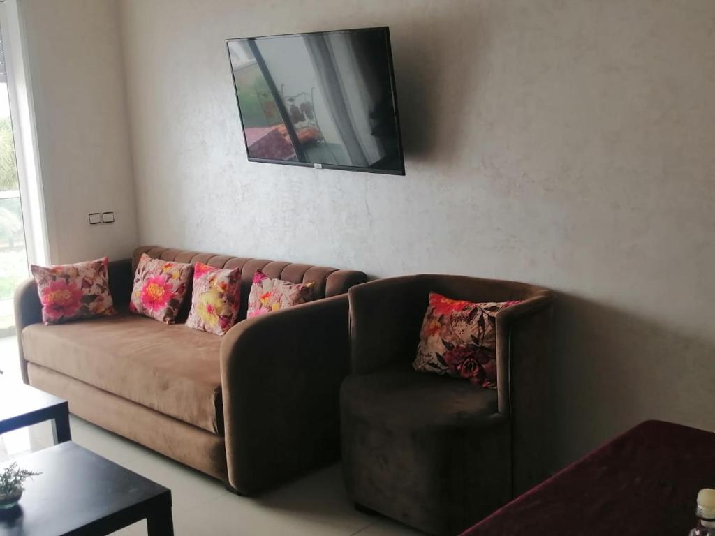 a living room with a couch and a mirror at Les terrasses 2 in Mansouria