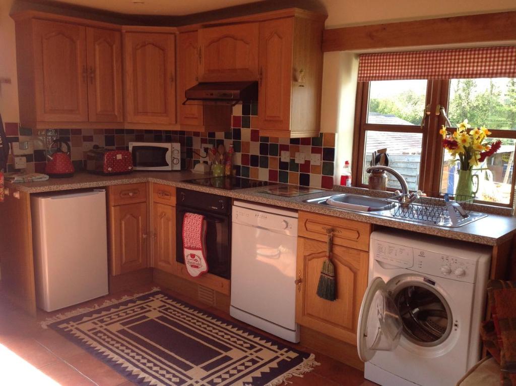 a kitchen with a washer and dryer in it at Hops and the Vines in Shipston on Stour