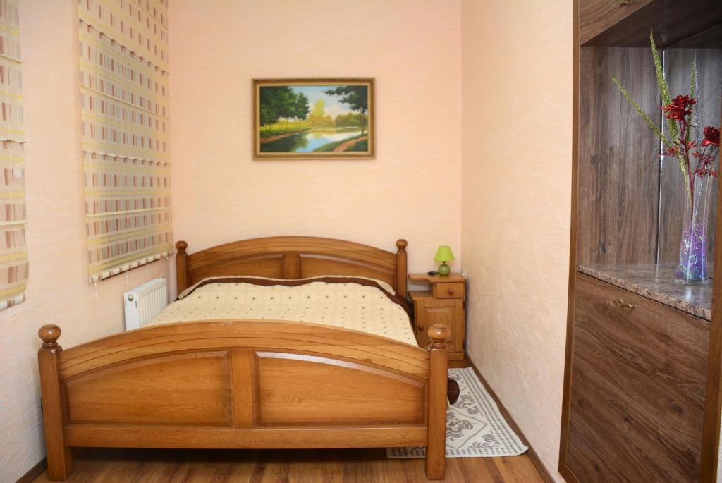 1 dormitorio con cama de madera en una habitación en Bazar Apartment en Chisináu
