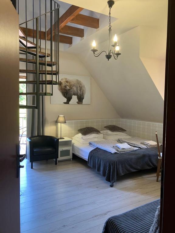 a attic room with a bed and a staircase at POKOJE GOŚCINNE Złote Modrzewie in Duszniki Zdrój