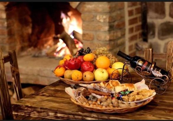 a table with two baskets of fruit and a fireplace at Marani Boutique in Tbilisi City