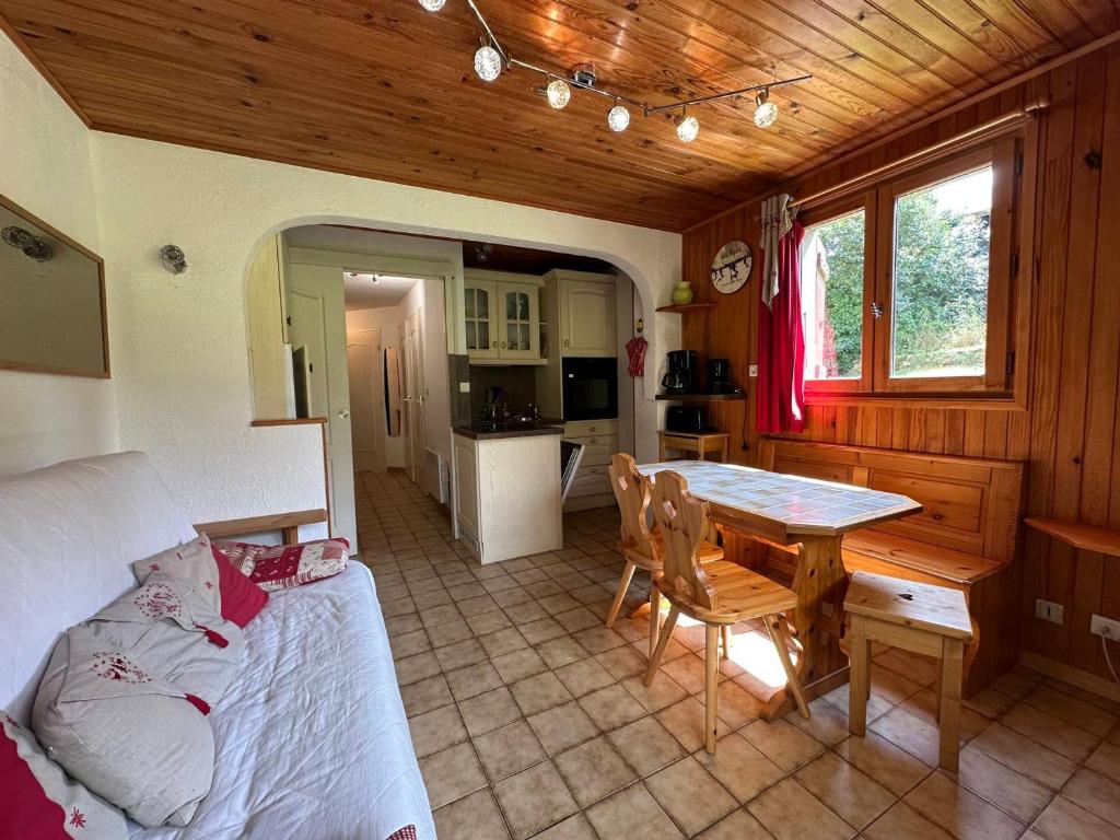 a living room with a table and a kitchen at Appartement cosy pour 4 pers avec terrasse, proche commerces et télécabine à Morillon - FR-1-642-43 in Morillon